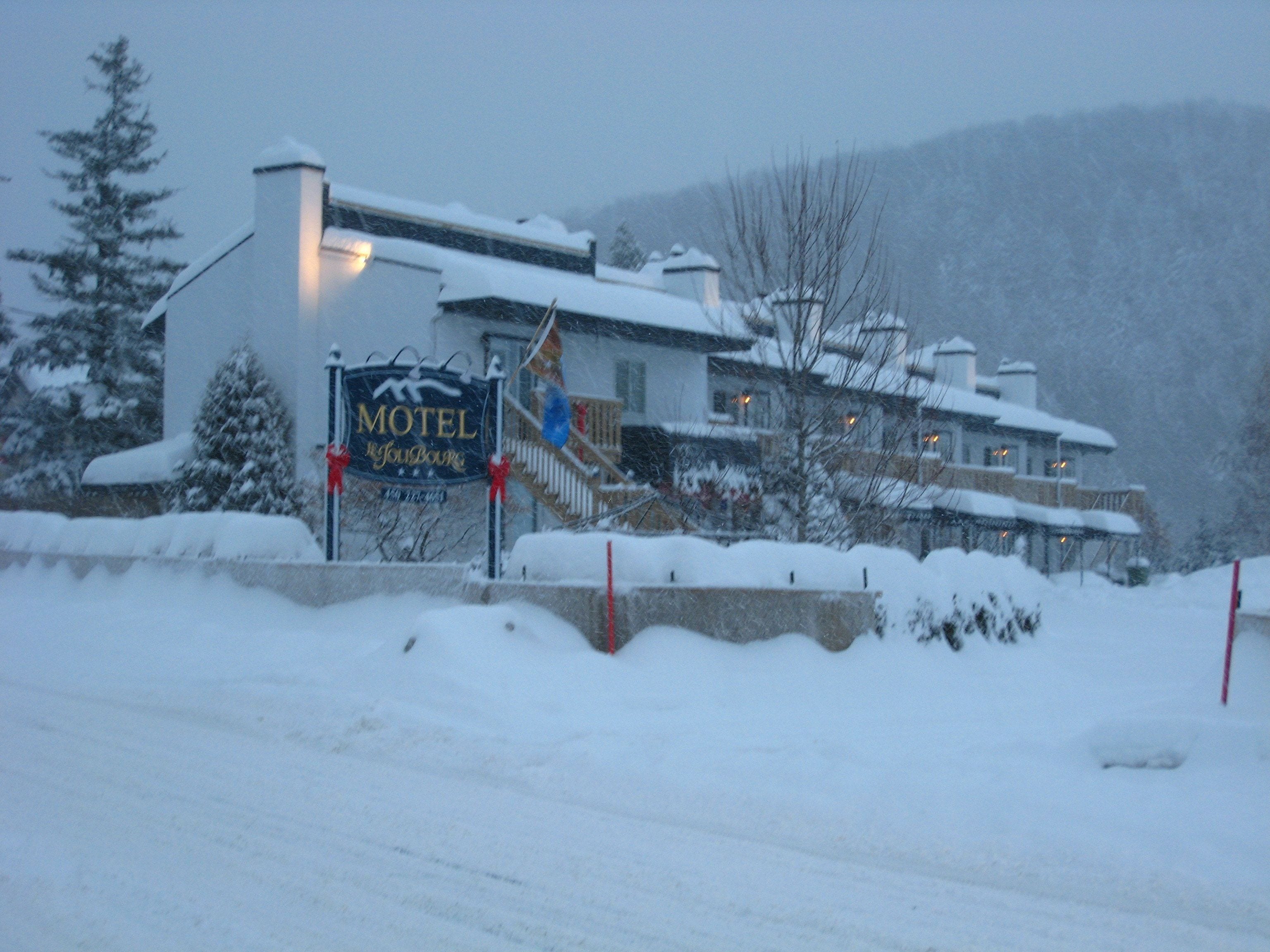 Een met sneeuw bedekt gebouw met een bord waarop 'Motel' staat.