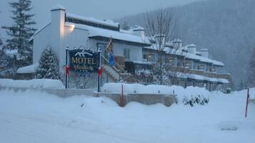A snow-covered building with a sign that reads "Motel."