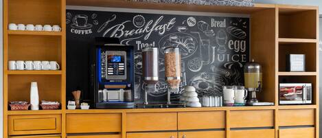 A breakfast bar with a coffee machine, a grinder, and a juice dispenser.