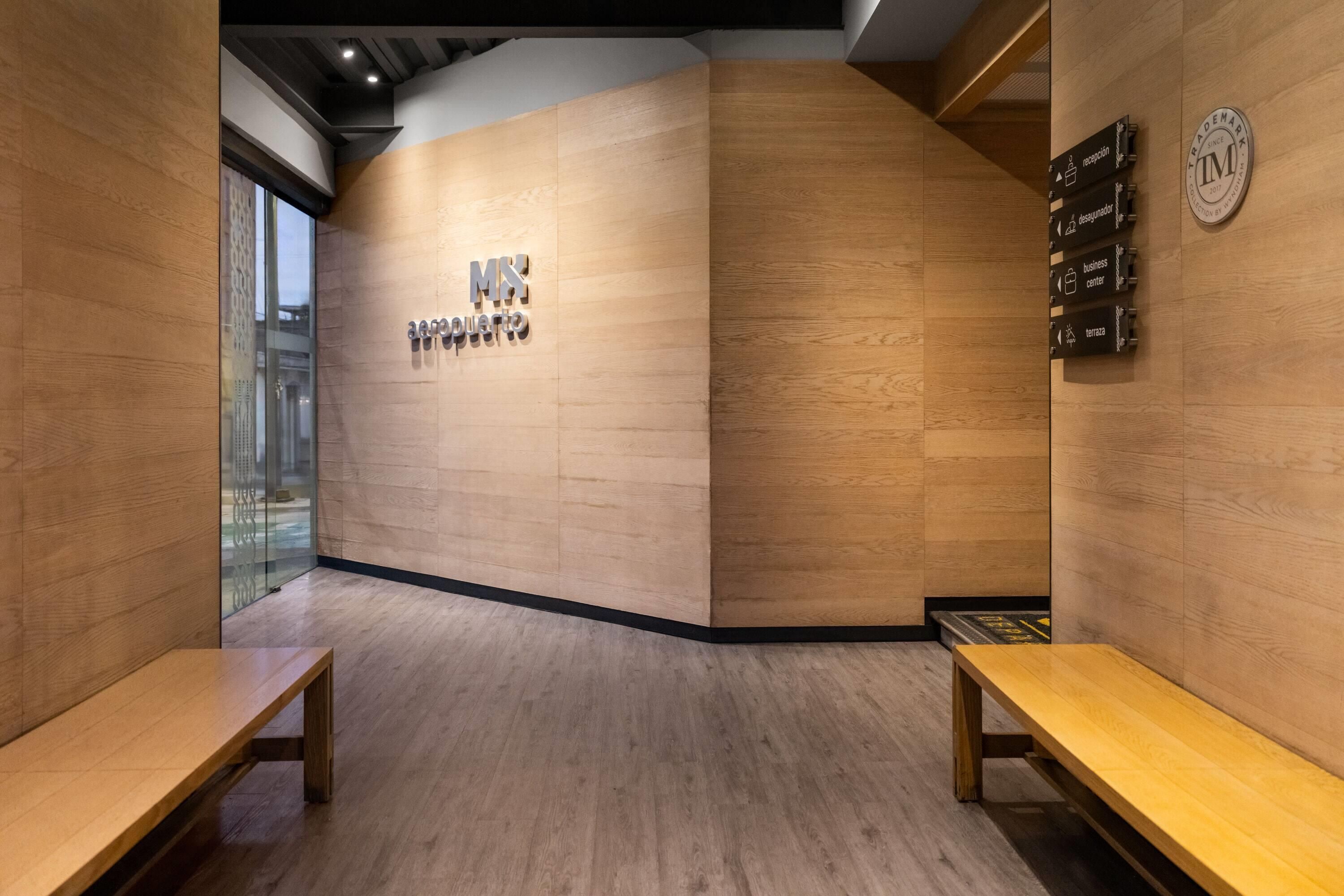 Un espace d’accueil avec un mur en bois, un comptoir d’accueil et des panneaux d’orientation.