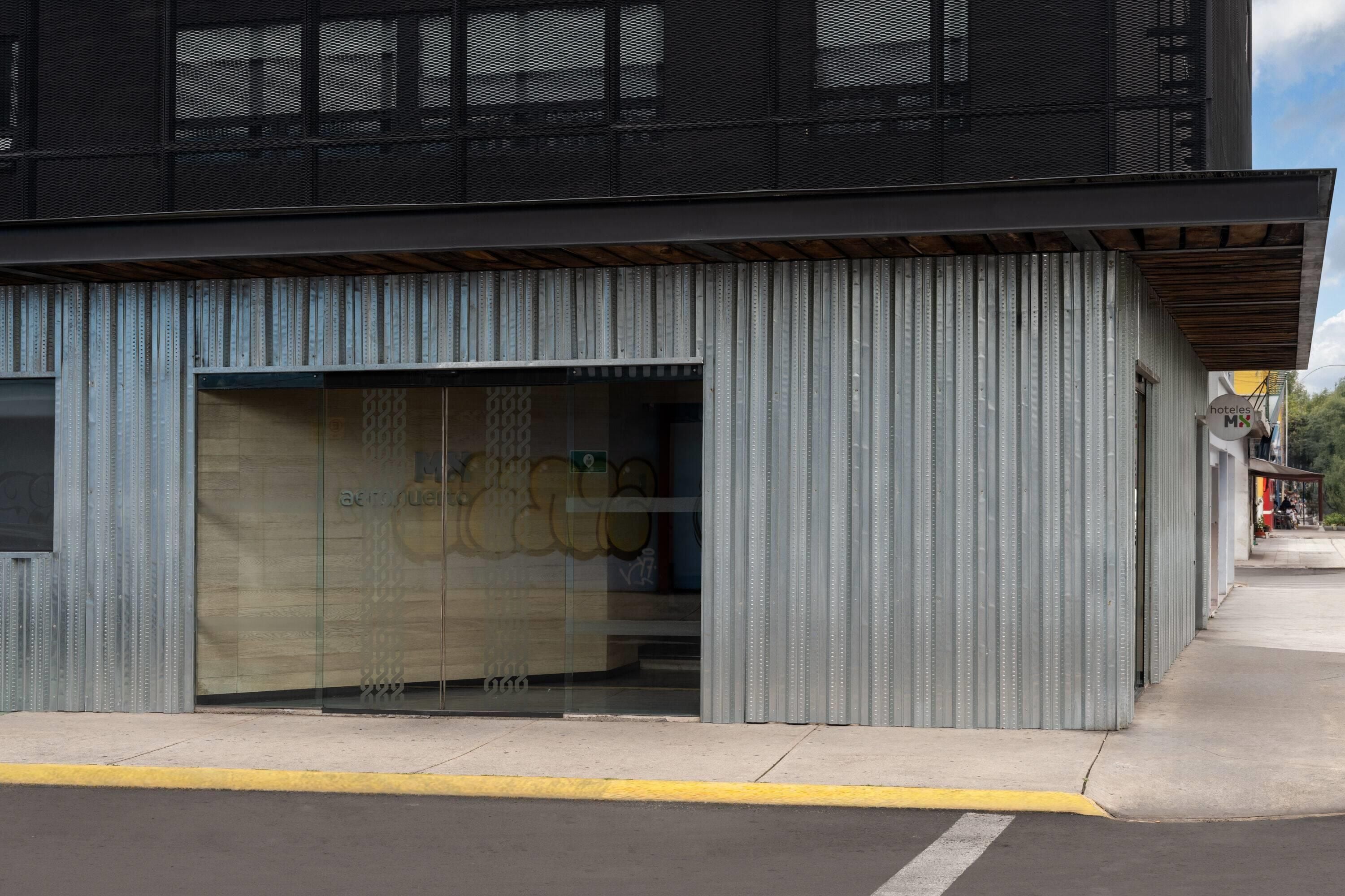 Un edificio moderno con una puerta de garaje grande y fachada metálica.