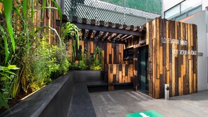 A wooden structure with a motivational quote, surrounded by greenery and a pathway.