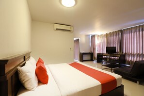Una camera d'albergo con un letto, una TV, una scrivania e un divano.