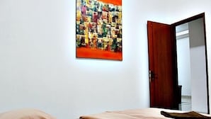 Une chambre à coucher avec un lit, un tableau au mur et une porte.
