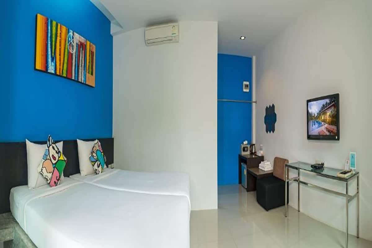 A hotel room with a large bed, a desk, and a television.