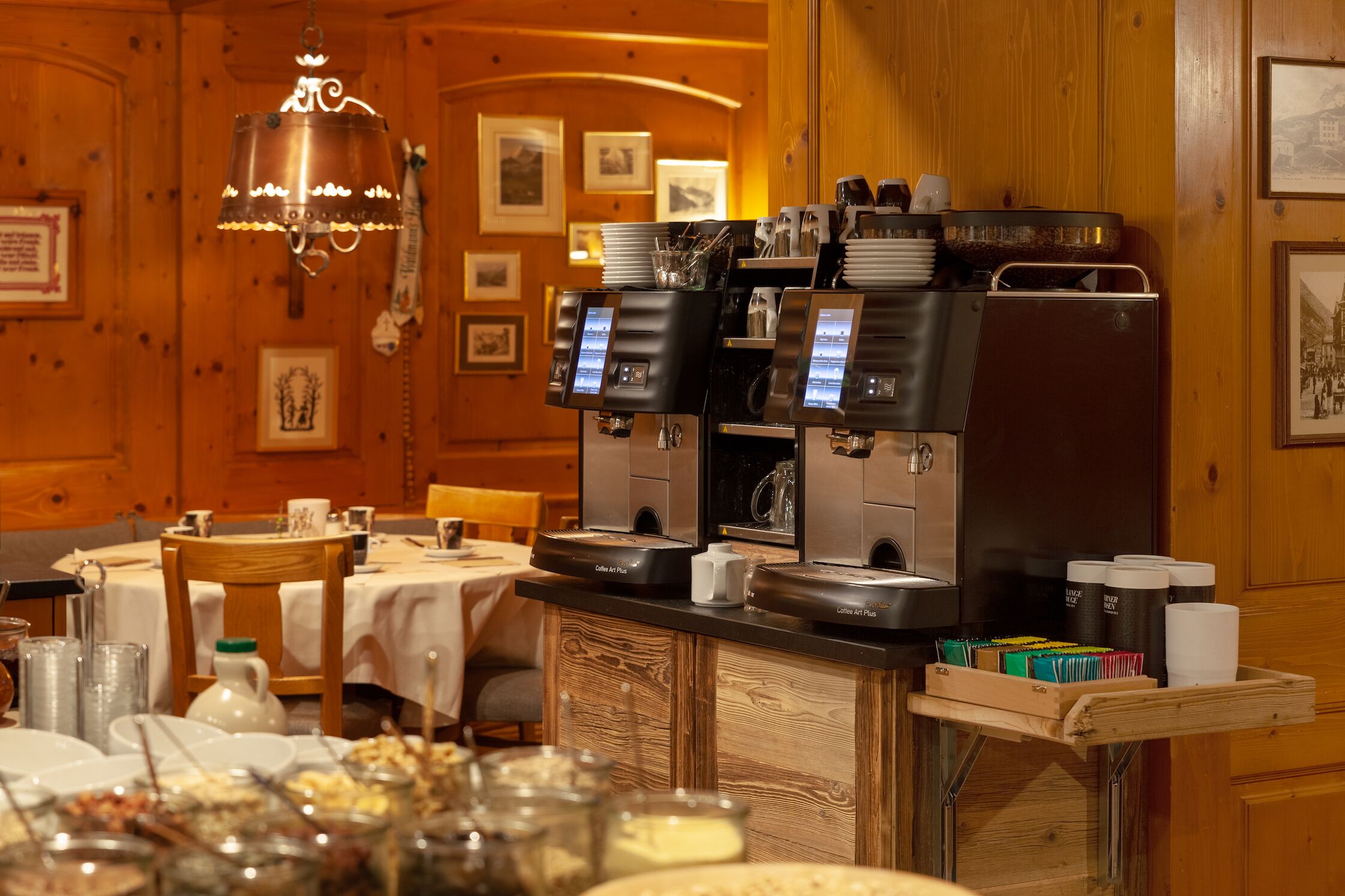Angolo caffè con diverse macchine per espresso, una caffettiera a stantuffo e un vassoio con tazze e posate.