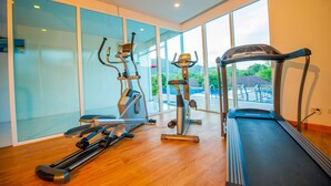 A home gym with cardio equipment including a treadmill, elliptical, and stationary bike. - Grand Nai Harn Suites (Rawai)