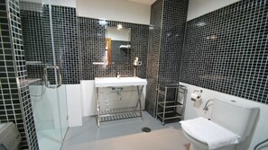 A bathroom with a white sink, a glass shower enclosure, and a toilet. - Living Sevilla Centro Maestranza (Seville)