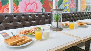 A restaurant setting with a table set for breakfast, including toast, a salad, and drinks.