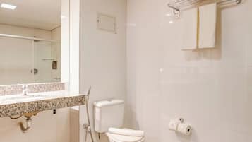 Un baño moderno con inodoro, lavamanos y toallero.