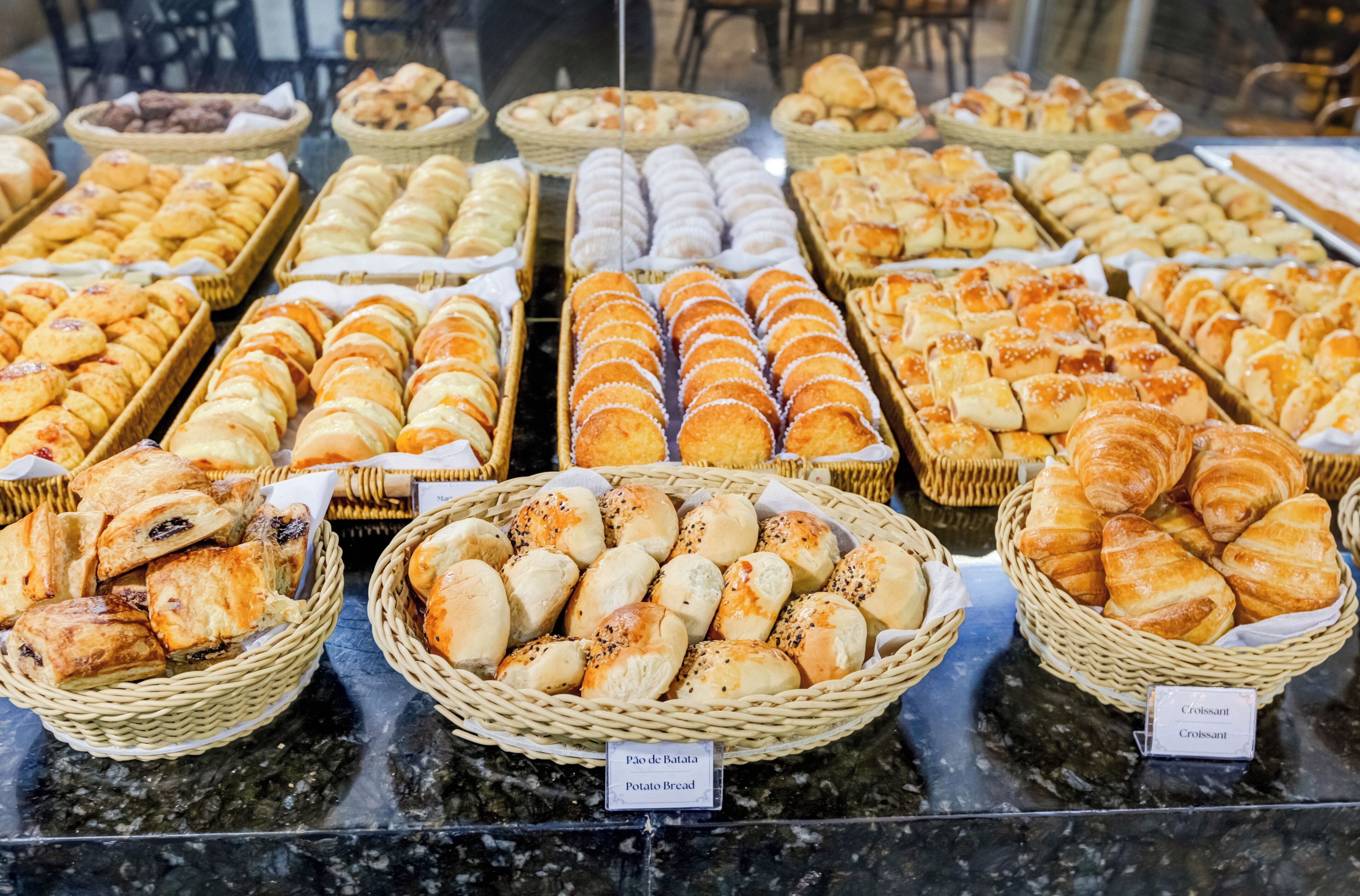 Mostrador de panadería con diversos productos horneados en cestas.