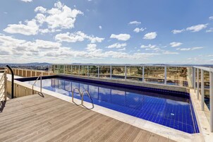 Una piscina al aire libre, sillones reclinables de piscina