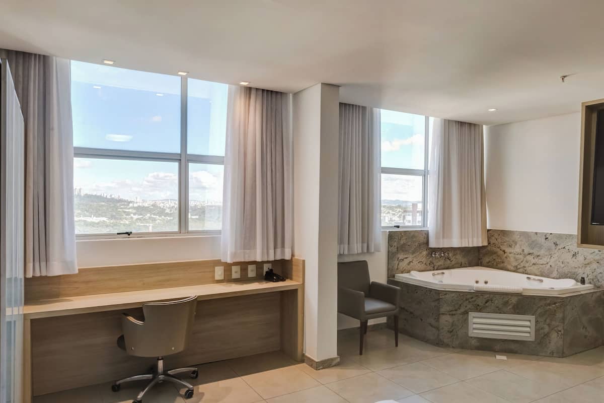 Suite Luxo com Banheira de Hidromassagem | 1 makuuhuone, ylelliset vuodevaatteet, minibaari, tallelokero huoneessa