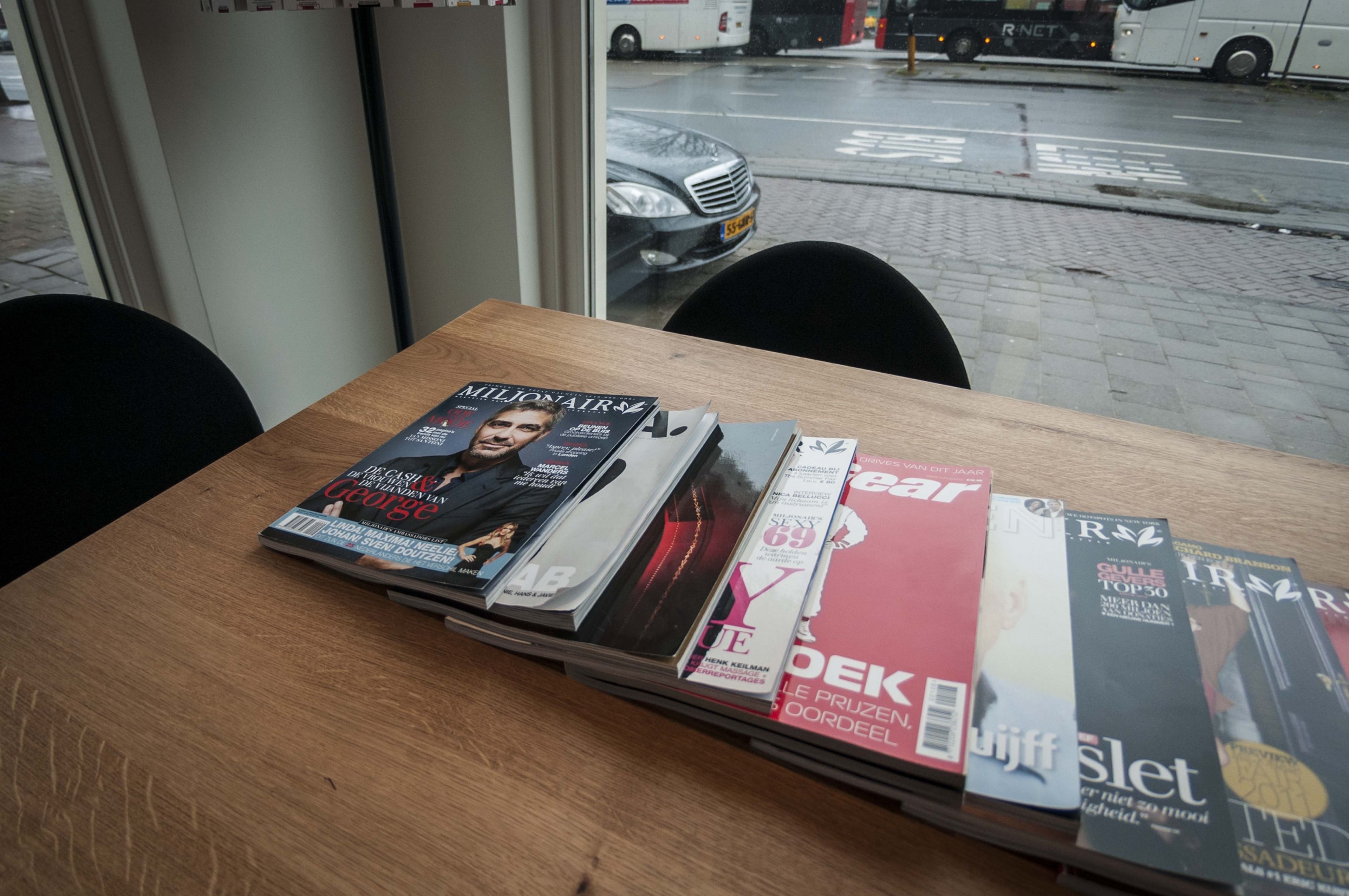 Una mesa con una pila de revistas.