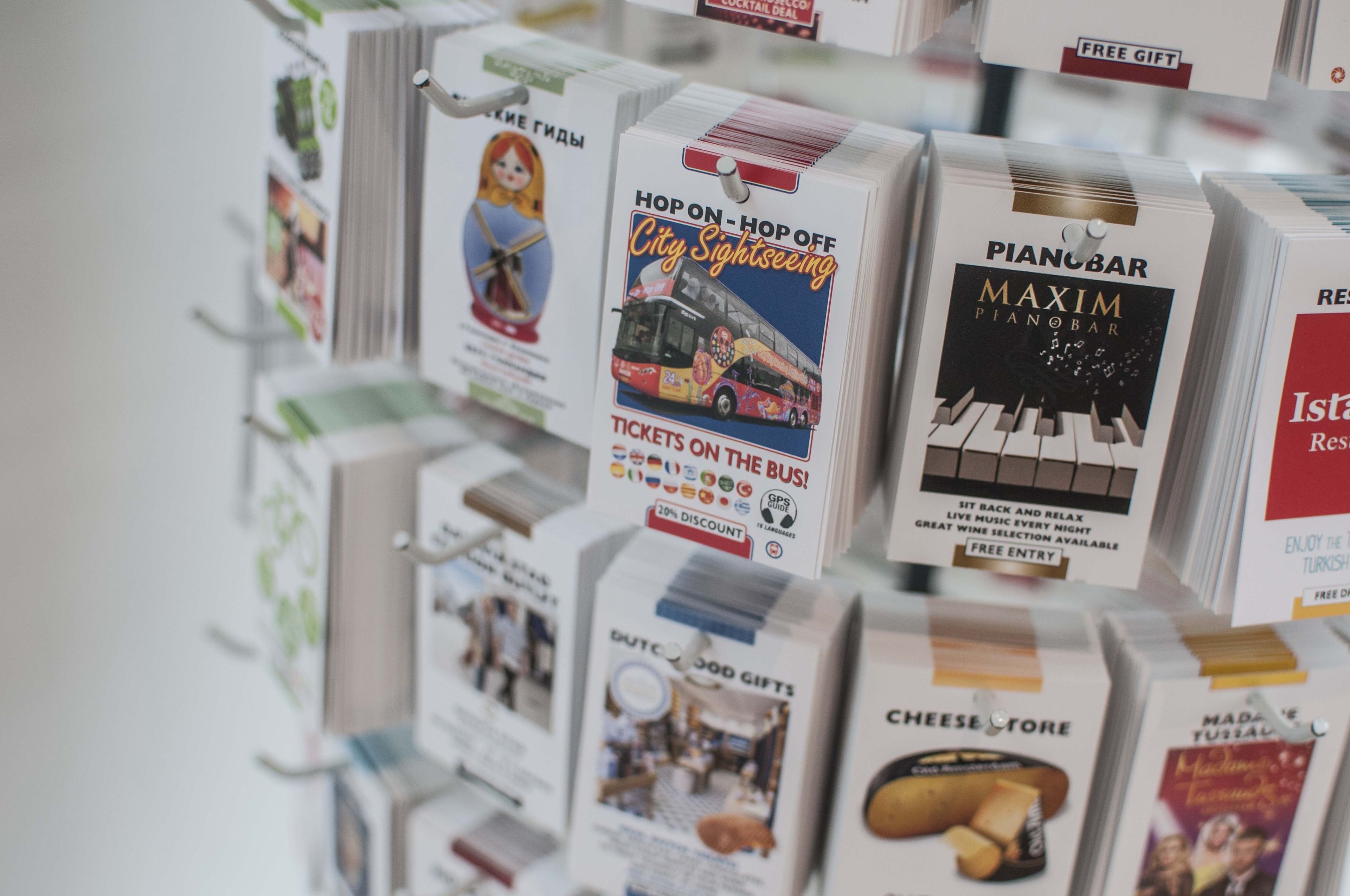 Exhibición de diversas cajas promocionales para recorridos turísticos por la ciudad, un bar con piano y una tienda de quesos.
