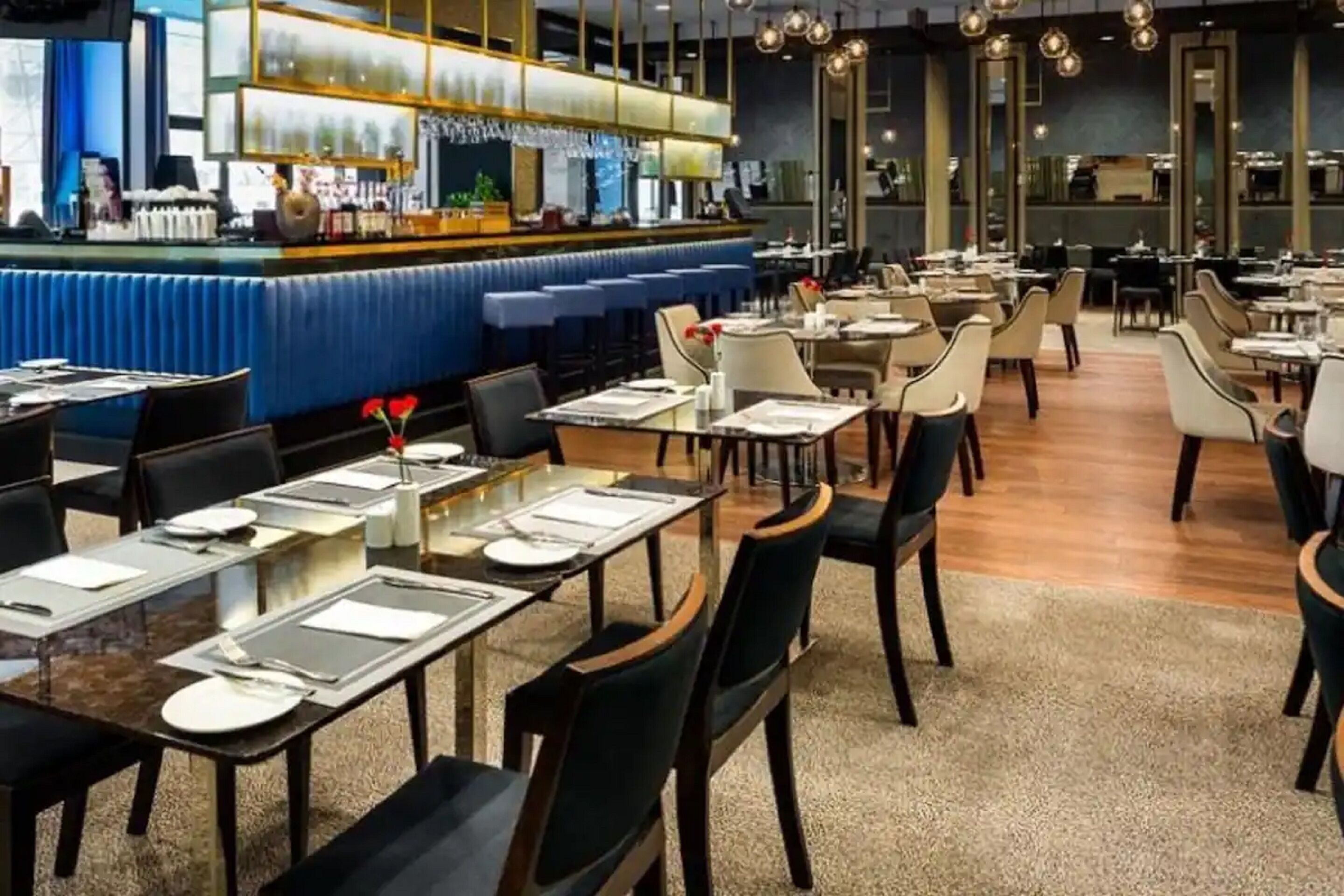 Un ristorante con zona bar, diversi tavoli e sedie.