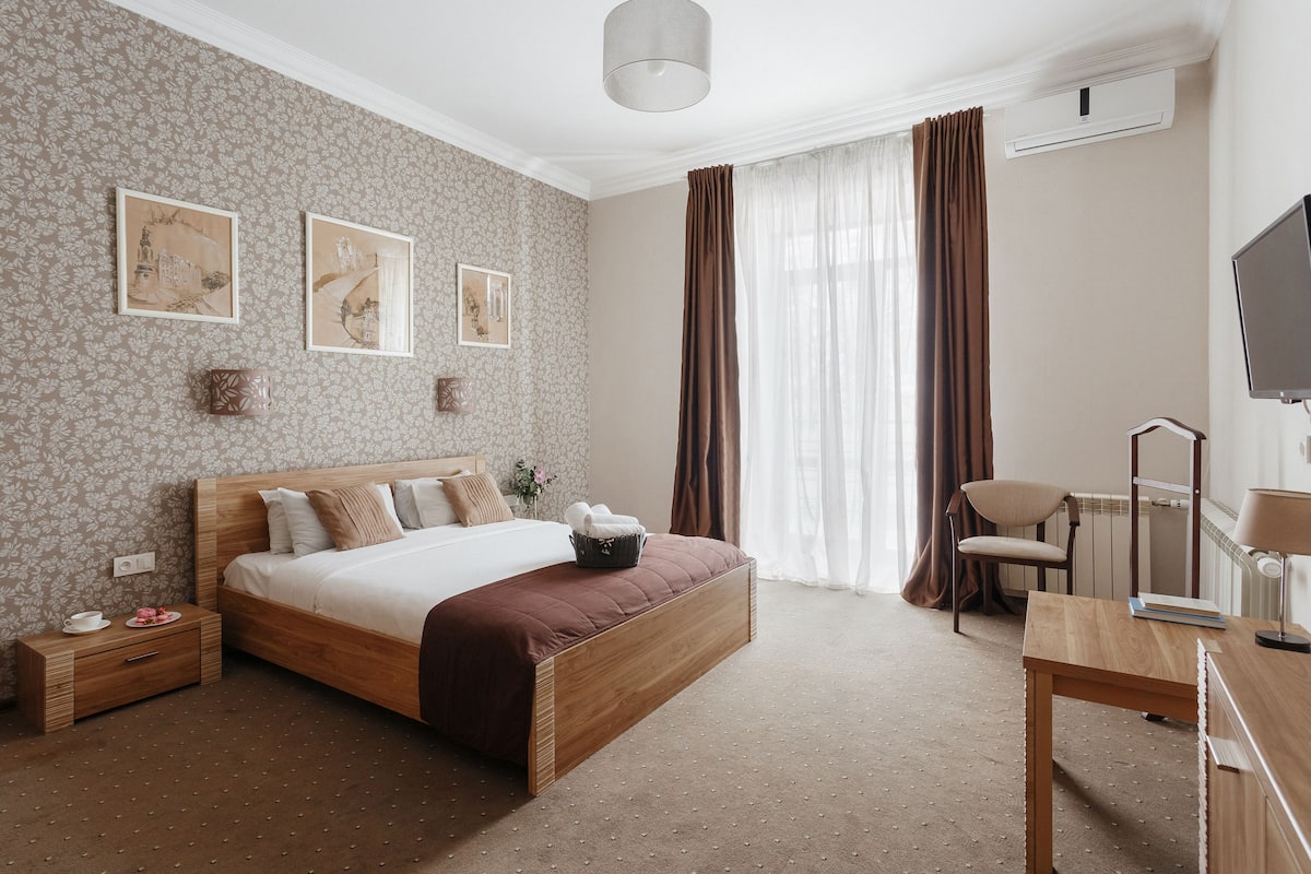 Un dormitorio con cama de madera, un escritorio, una silla y un televisor.