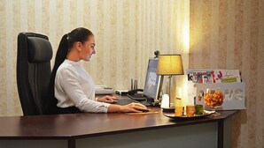 A woman working at a desk with a computer, a lamp, and a menu board. - Ribas (Odesa)