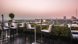 A terrace with a table and chairs, overlooking a cityscape.