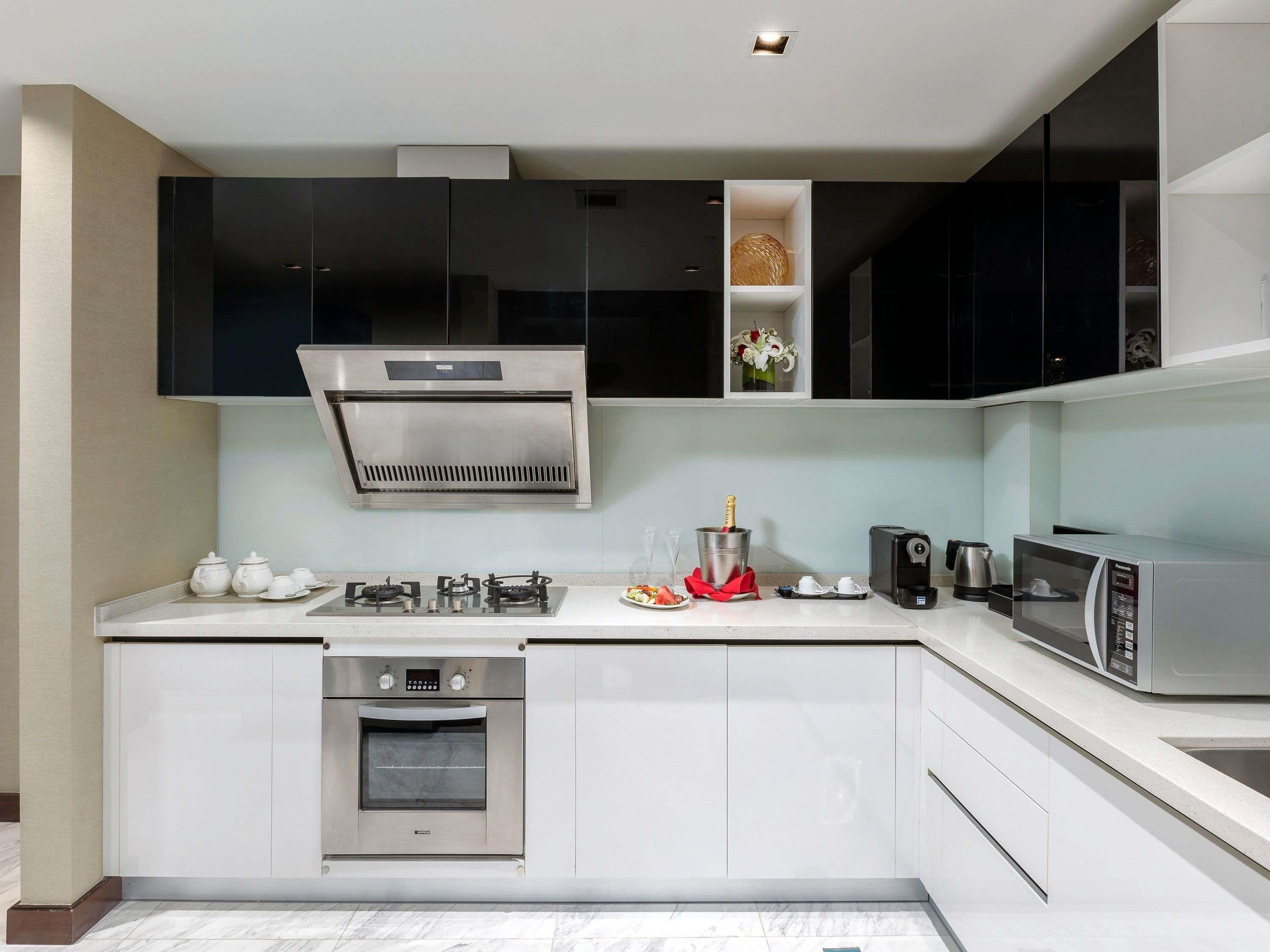 A modern kitchen with a built-in oven, a microwave, and a gas stove.