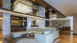 A spacious living area with a modern sofa set, a coffee table, and a chandelier.