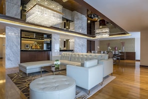 A spacious living area with a modern sofa set, a coffee table, and a chandelier.
