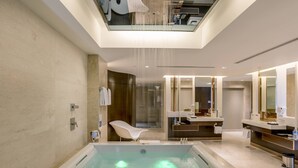 A modern bathroom with a large bathtub, a separate shower area, and a vanity with a mirror.
