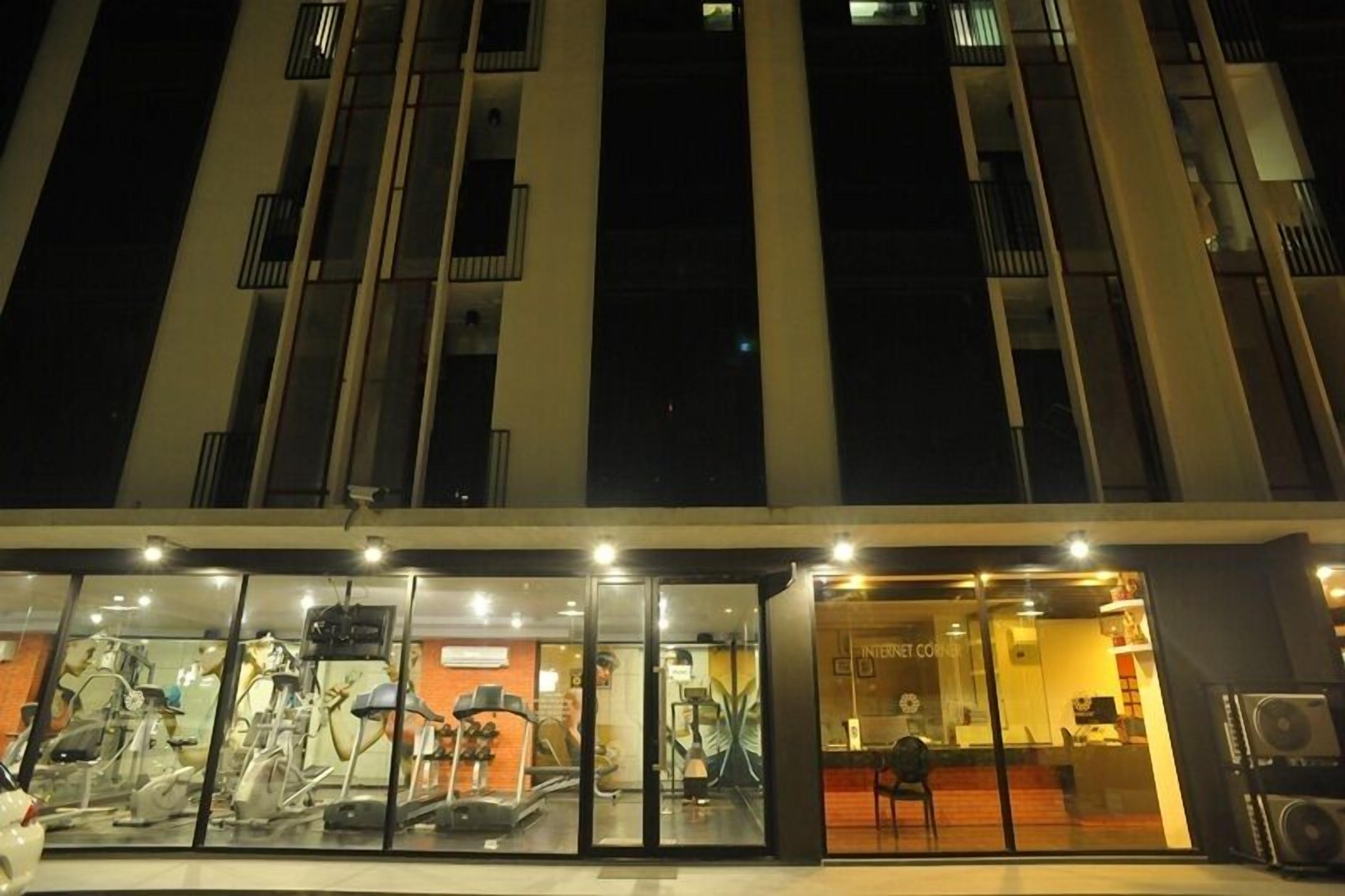 A modern building with a glass storefront displaying exercise equipment.