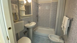 A bathroom with a toilet, sink, and bathtub. - Via Mameli 5 Inn (Sanremo)