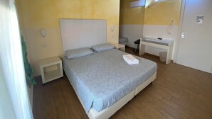 A bedroom with a bed, bedside tables, a desk, and a mirror. - Via Mameli 5 Inn (Sanremo)
