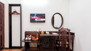 A room with a wooden desk, a television displaying 'BREAKING NEWS', a mirror, and a wooden chair. - Little Hanoi Hotel (Hanoi)