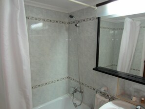 A bathroom with a bathtub, a shower, a sink, and a mirror. - Arenal (Sant Antoni de Portmany)