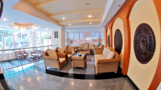 A spacious lobby with wicker furniture, large windows, and decorative wall art. - Golden Villa (Pattaya)
