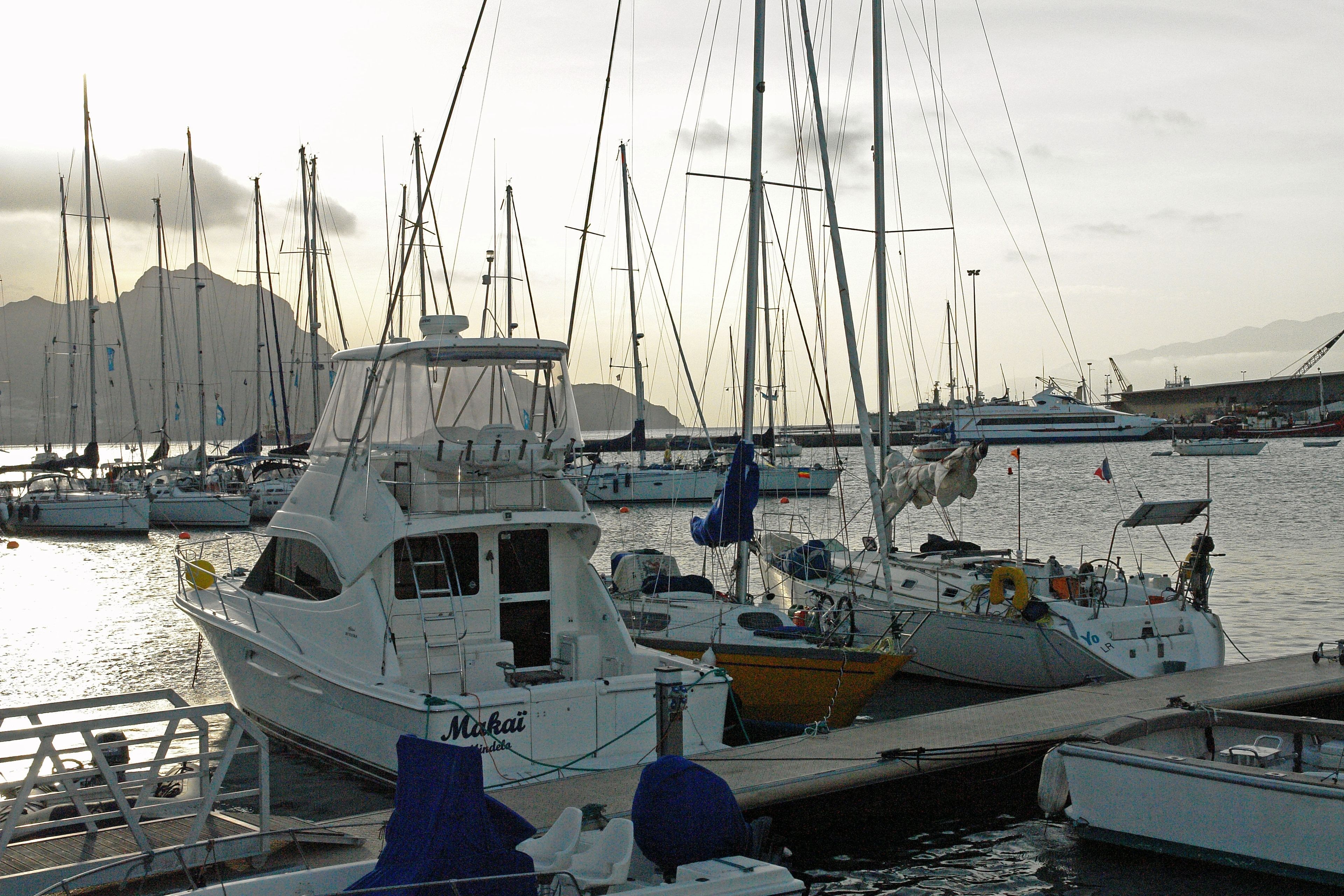 A marina with various boats docked, including a white boat with 'Makai' written on it.