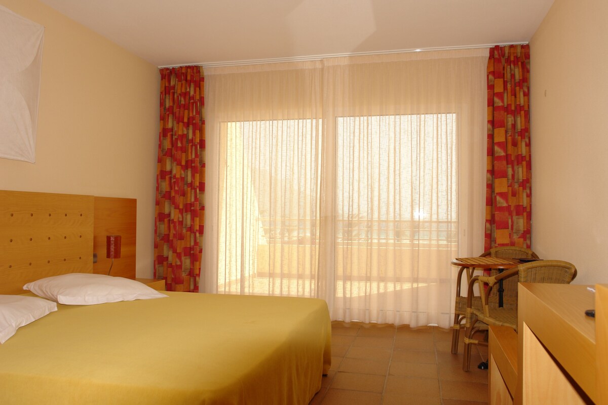 Una habitación de hotel con cama, escritorio y silla.