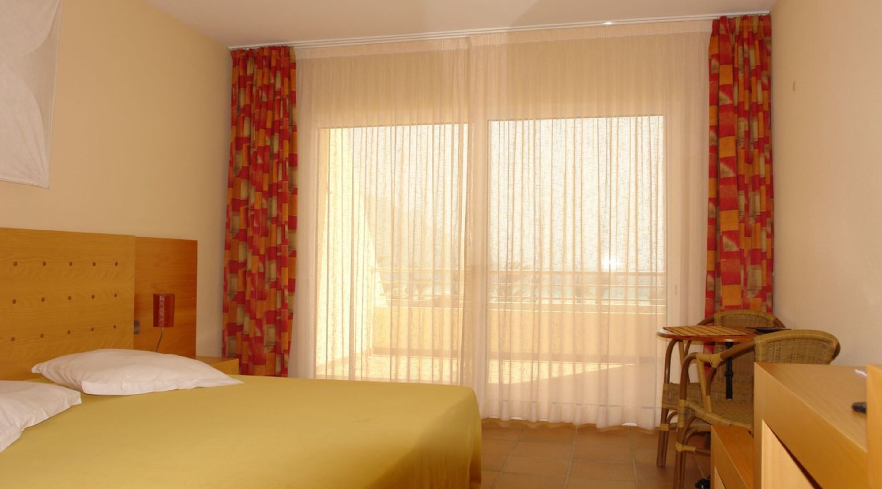 Une chambre d’hôtel avec un lit, un bureau et une chaise.