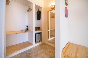 Ein gemütlicher Raum mit eingebauter Minikühlschrank, einem kleinen Heizgerät und einem Holzboden.
