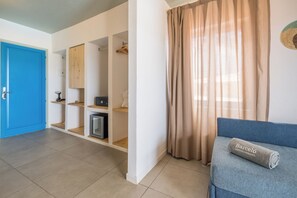 Ein Zimmer mit blauer Tür, einem Sofa und einem eingerollten Handtuch sowie einem Vorhang.