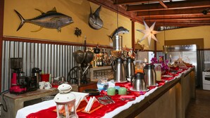 A bar area with a long counter, various coffee and tea brewing equipment, and decorative fish mounted on the wall. - The Colonial Guest House (São Filipe)