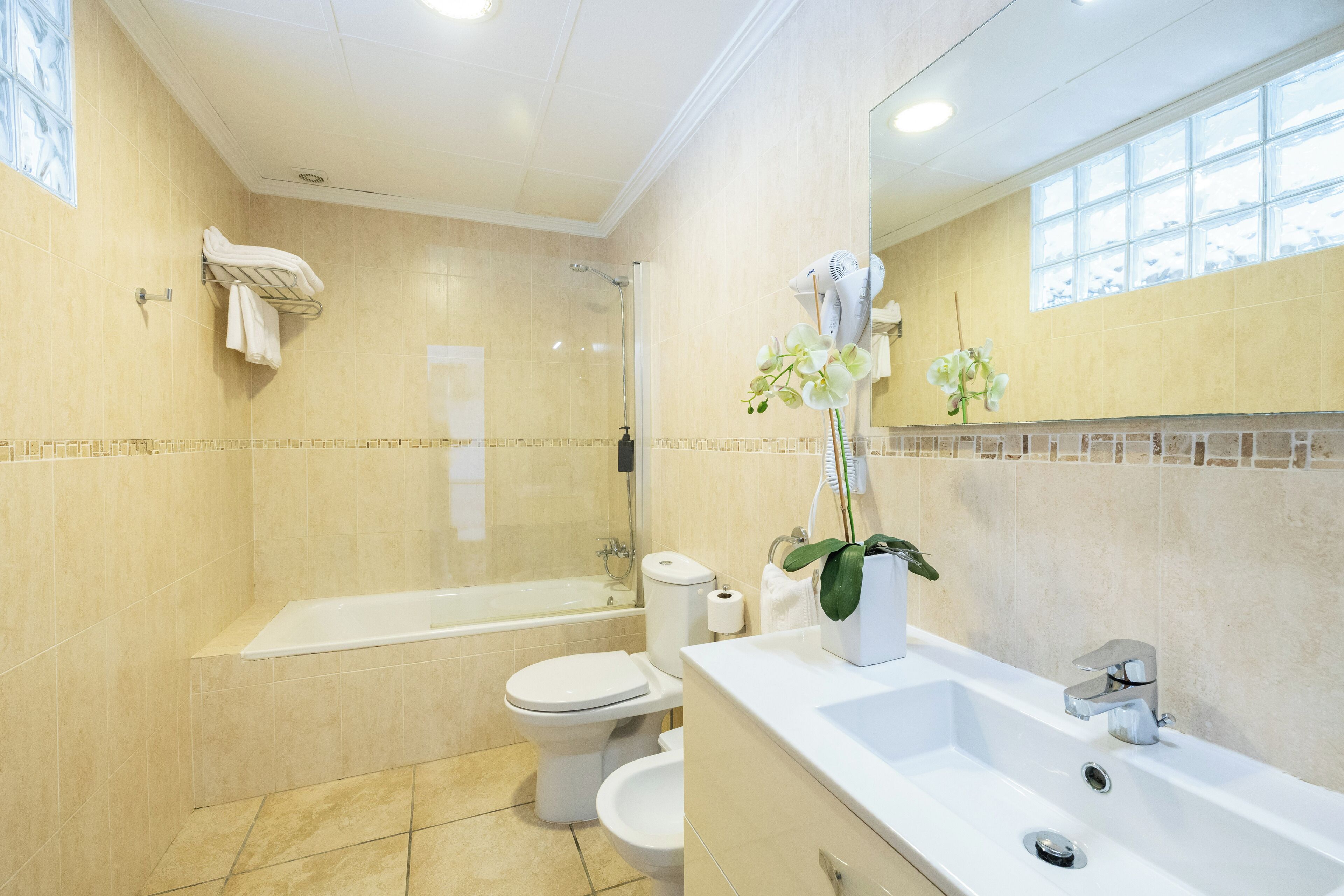 A modern bathroom with a bathtub, toilet, and sink.