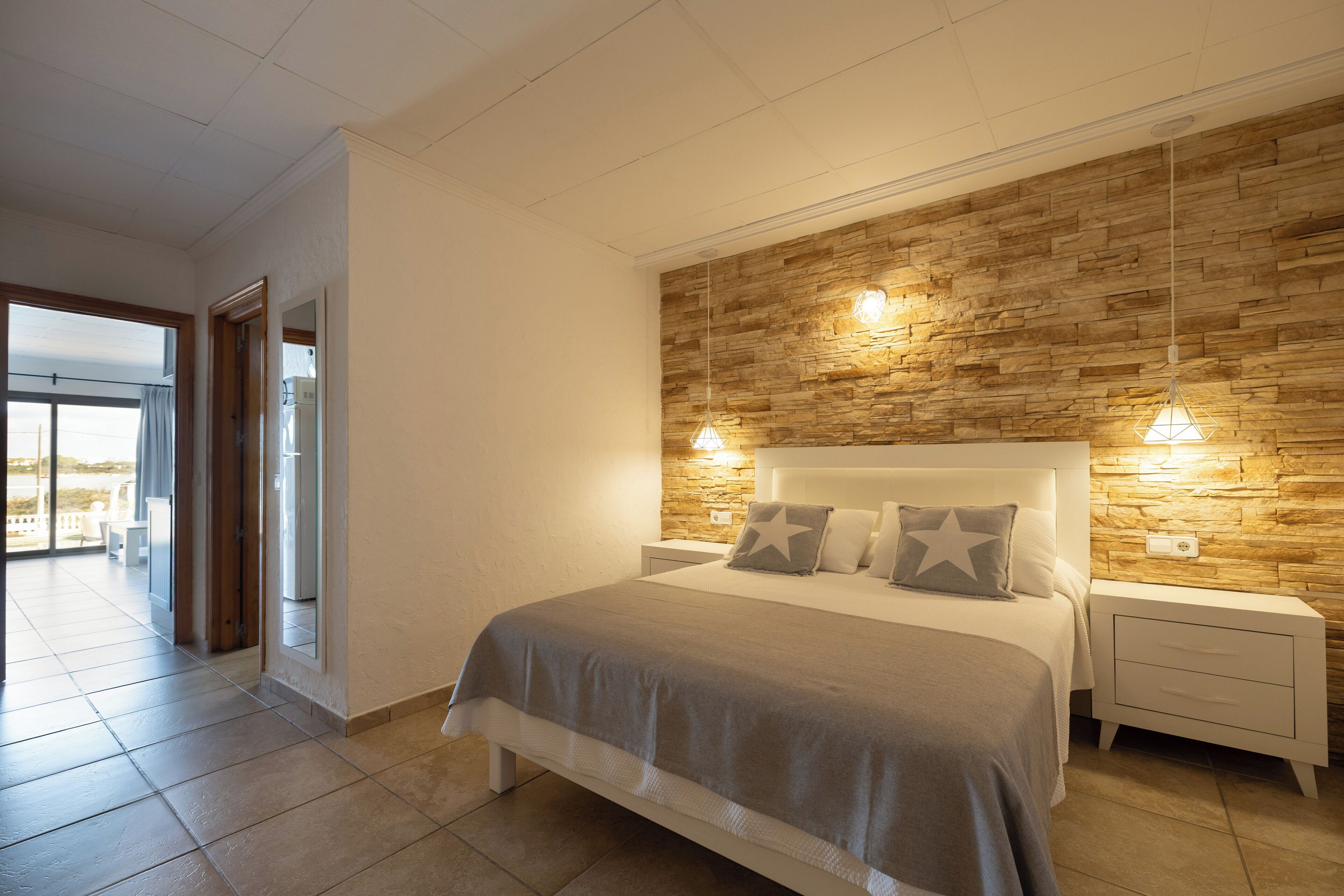 Un dormitorio moderno con una cama grande, una pared de acento de madera y dos lámparas de noche.