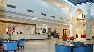A lobby with a reception desk, seating area, and decorative elements.