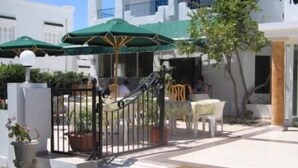 A courtyard with outdoor seating, a staircase, and a gate. - Hotel Les Citronniers (Hammamet)
