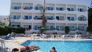 A hotel with a pool area, multiple balconies, and outdoor seating. - Hotel Les Citronniers (Hammamet)