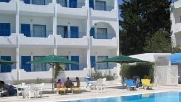 A white building with multiple balconies and a swimming pool. - Hotel Les Citronniers (Hammamet)