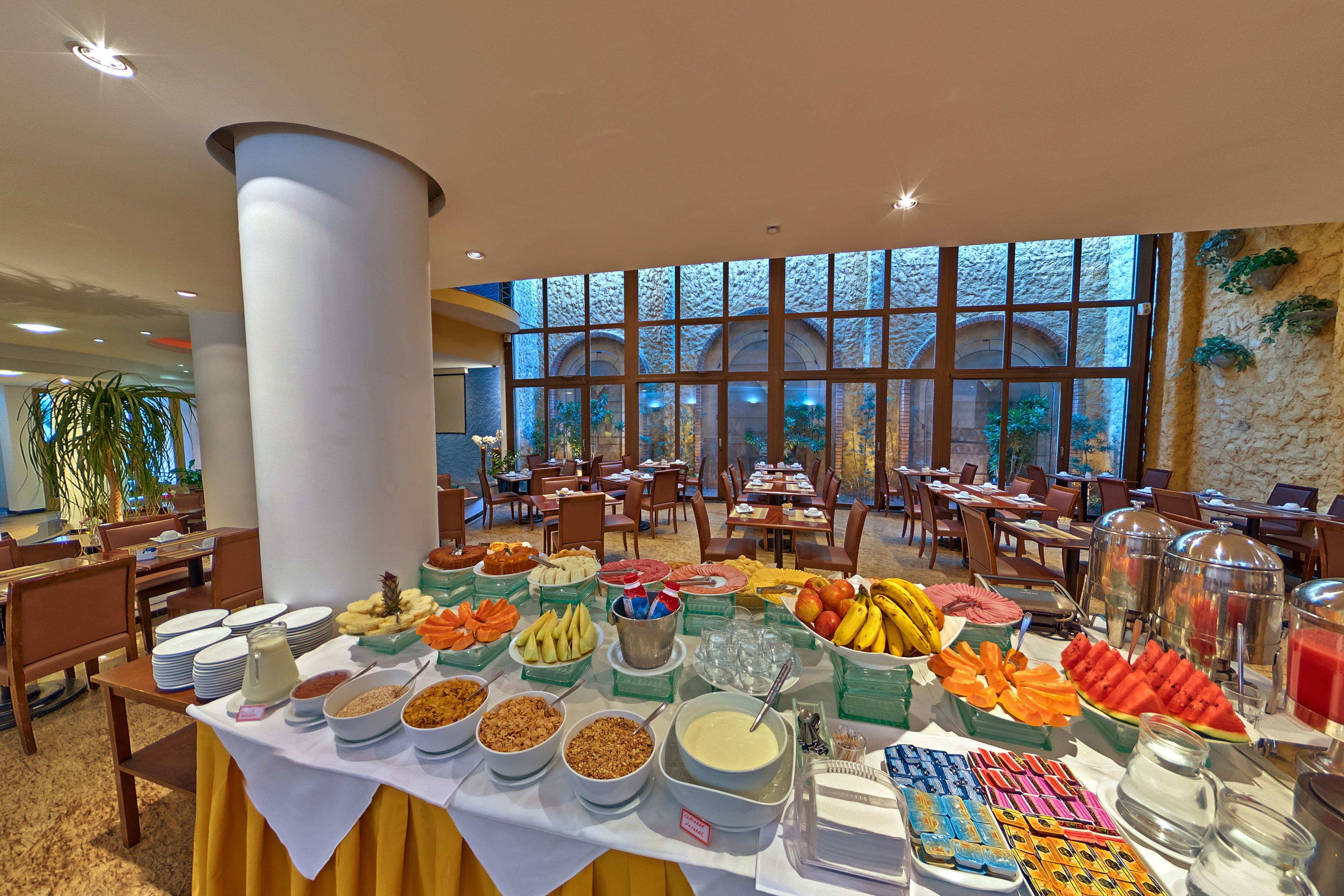 A buffet with various food items and a large window in the background.