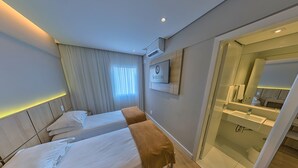 A hotel room with two beds, a bathroom with a glass shower, and a sign on the wall. - Shelton Hotel (Serra Negra)