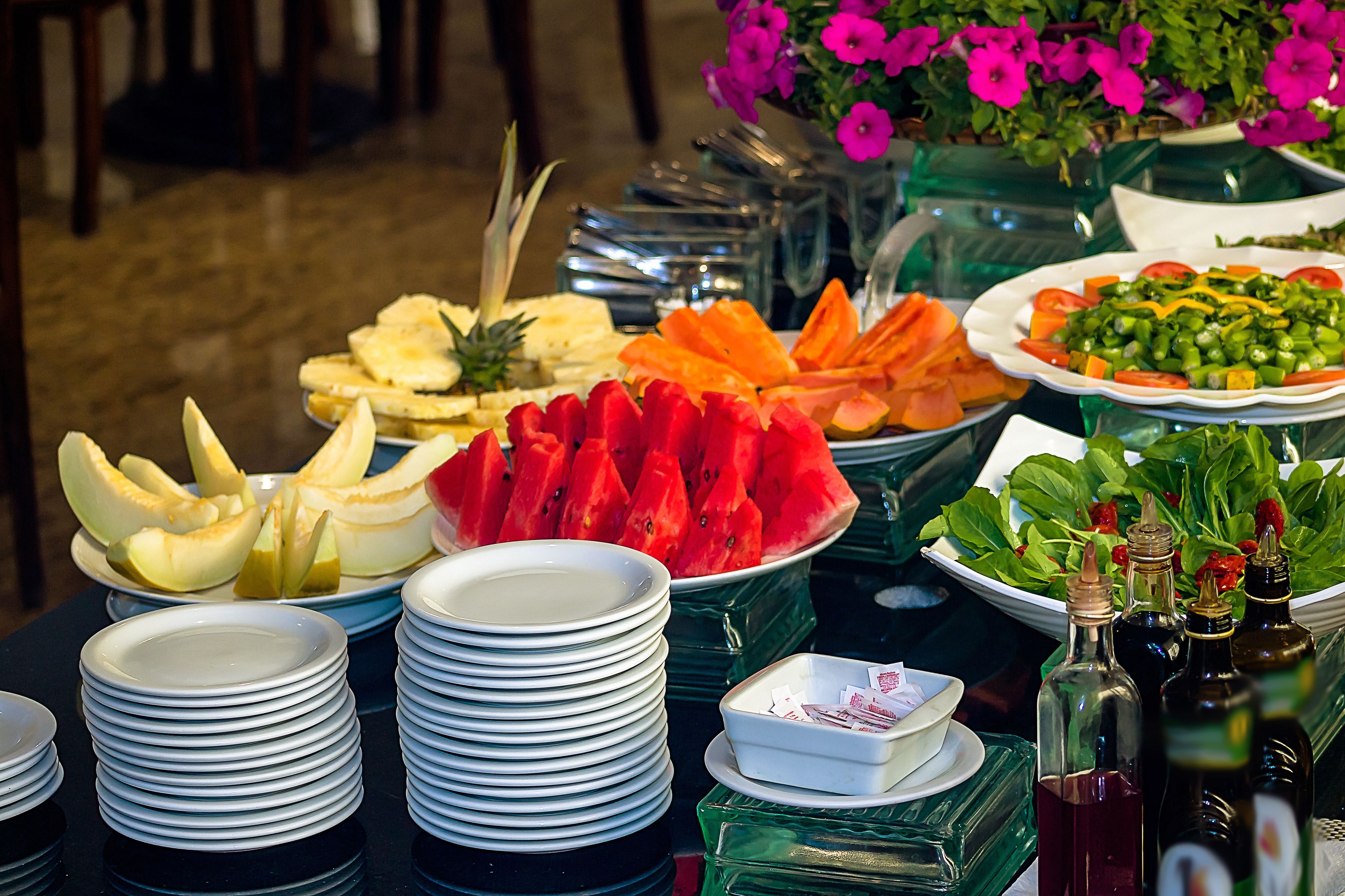 A buffet table with various food items and condiments.