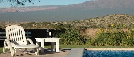 Una piscina al aire libre, tumbonas