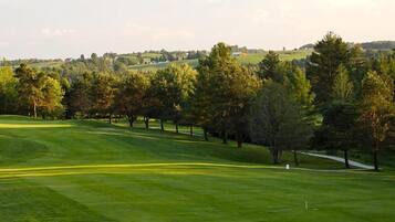Enjoy a serene golfing experience amidst rolling hills and lush trees.